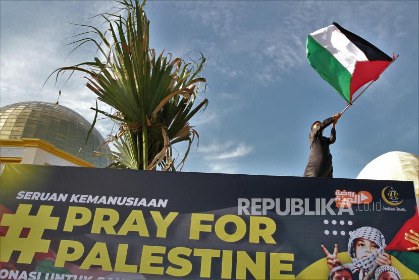 Seorang anak mengibarkan bendera Palestina di Masjid Raudhatul Jannah saat aksi solidaritas donasi untuk Palestina, Kota Kendari, Sulawesi Tenggara, Rabu (19/5/2021).