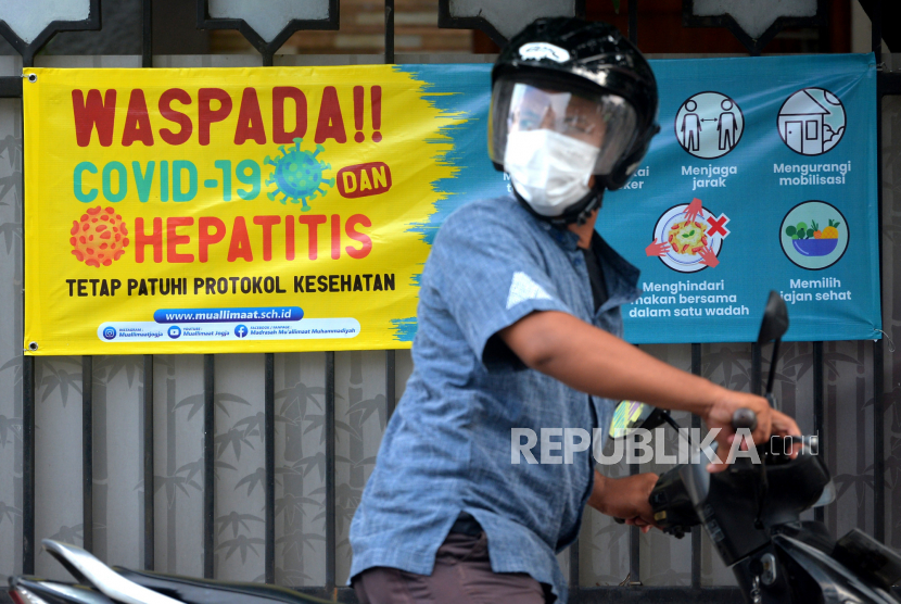 Spanduk imbauan waspada terhadap Covid-19 dan Hepatitis terpasang di depan Madrasah Muallimat, Yogyakarta, Jumat (20/5/2022). Memakai masker menjadi kebiasaan yang baik karena dapat menjaga kesehatan.