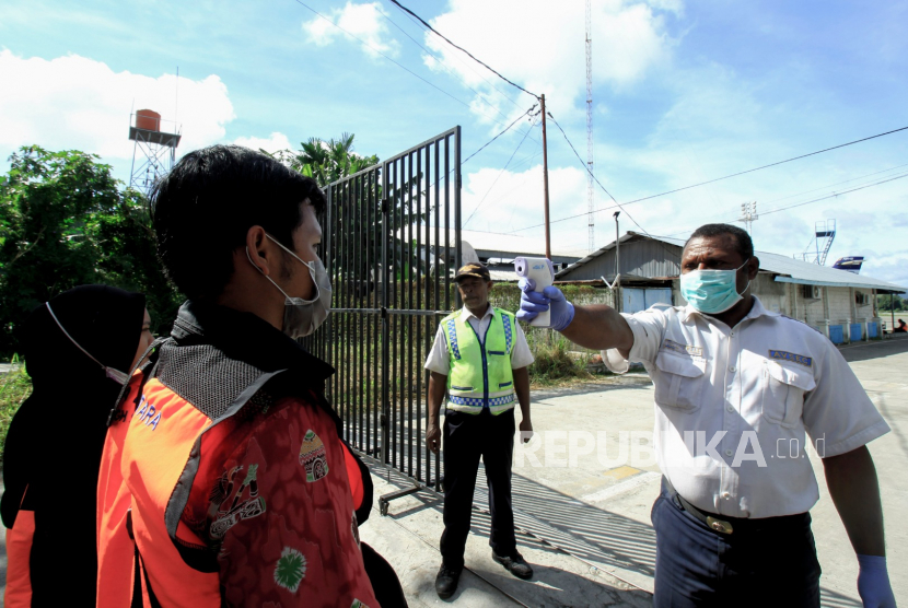 Petugas mengukur suhu sebelum beraktivitas di Bandara Sentani, Jayapura, Papua, Jumat (27/3/2020). Pemprov Papua menutup penerbangan penumpang ke seluruh bandara di Papua sejak 26 Maret hingga 4 April untuk mencegah penyebaran virus corona atau COVID-19
