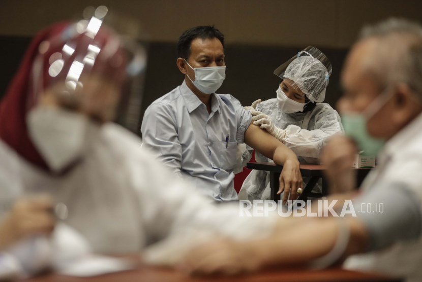 Seorang pria menerima suntikan vaksin booster Covid-19 Pfizer selama perjalanan vaksinasi di Jakarta, Indonesia, 18 Januari 2022. 