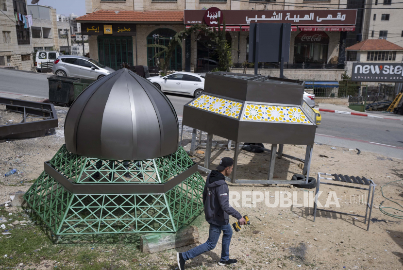 Buruh Palestina mengerjakan monumen bergaya Islam yang terdiri dari lentera dan bulan sabit, dua ikon simbolik bulan suci Ramadhan, di kota Ramallah, Tepi Barat, Selasa, 29 Maret 2022. Dewan Hak Asasi Manusia Perserikatan Bangsa-Bangsa (PBB) pada Jumat (1/4/2022) mengadopsi tiga resolusi yang mendukung Palestina.