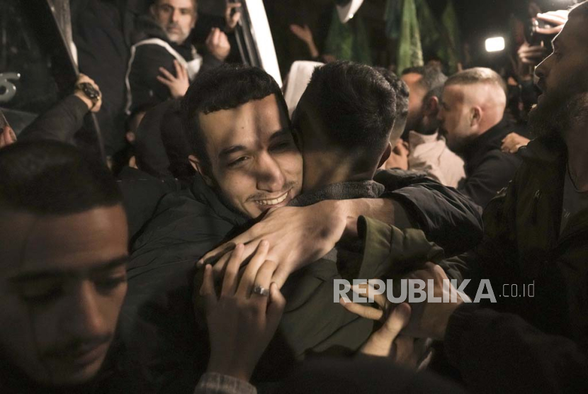 A man smiles as he is welcomed after being released from prison by Israel, in the West Bank town of Ramallah, early Thursday, Nov. 30, 2023. International mediators on Wednesday worked to extend the truce in Gaza, encouraging Hamas militants to keep freeing hostages in exchange for the release of Palestinian prisoners and further relief from Israel