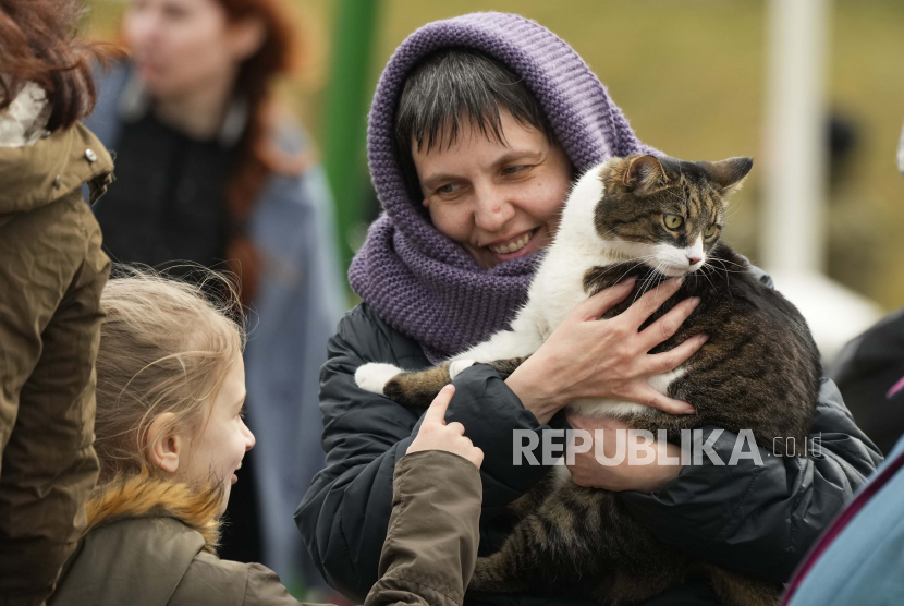 Larisa Pradko, seorang pengungsi dari Kharkiv, menggendong kucingnya Felix setelah melarikan diri dari perang dari negara tetangga Ukraina di perbatasan di Medyka, Polandia tenggara, Rabu, 6 April 2022. UEA Kirim 50 Ton Bantuan untuk Pengungsi Ukraina di Polandia