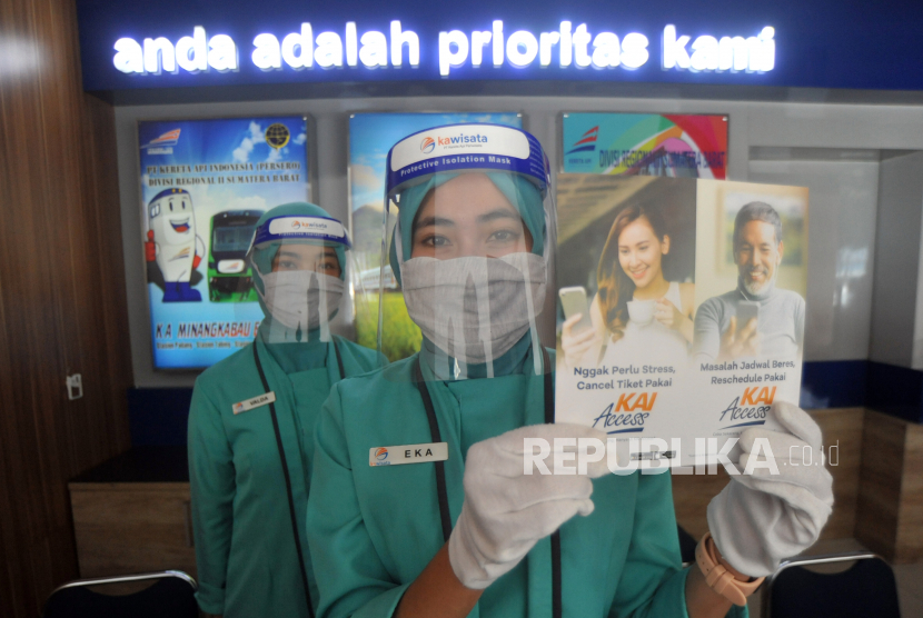 Petugas loket menggunakan APD menunjukan brosur untuk memesan dan refund tiket kereta api di Stasiun Simpang Haru, Padang, Sumatera Barat, Rabu (1/7/2020). PT KAI Divre II Sumbar memperpanjang pembatalan semua perjalanan kereta api penumpang hingga 31 Juli 2020, karena mempertimbangkan situasi tingkat penyebaran COVID-19 di daerah itu serta menyesuaikan kebijakan dari pusat. 