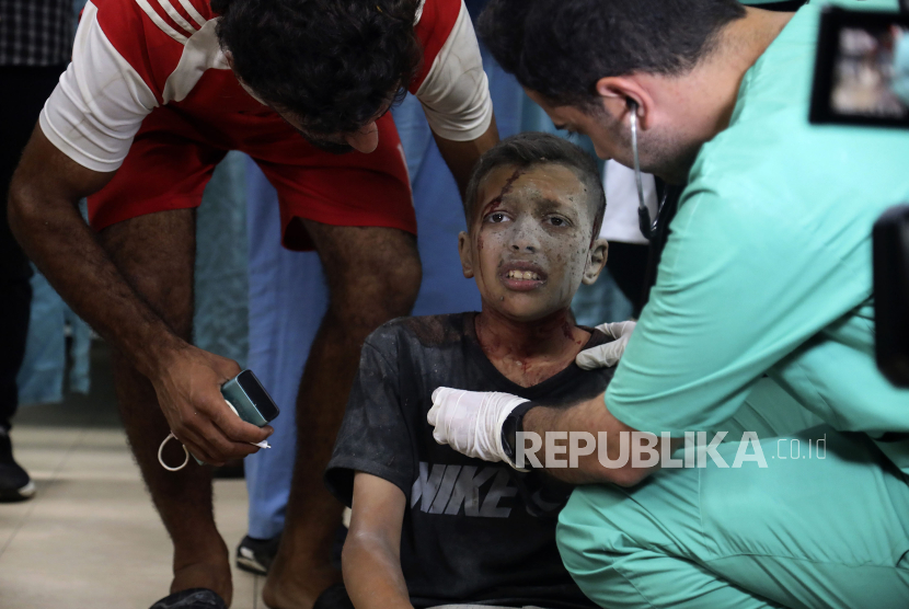 Petugas medis Palestina merawat seorang anak yang terluka akibat pemboman Israel terhadap sebuah bangunan tempat tinggal di Rumah Sakit Martir al-Aqsa di Deir al Balah, Jalur Gaza tengah, Senin (24/6/2024)