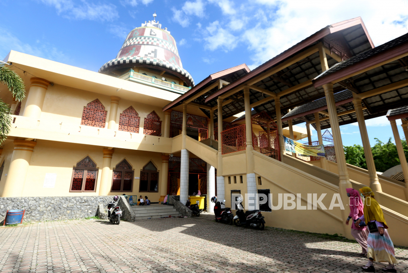 Warga muslim berjalan memasuki Masjid Baitul Musyahadah di Gampong Geuceu Kayee Jato, Banda Aceh, Aceh, Jumat (23/4/2021). Masjid Baitul Musyahadah merupakan satu-satunya masjid di Banda Aceh yang memiliki kubah berbentuk kupiah yang juga dikenal dengan sebutan Masjid Kupiah Meukeutop (topi tradisional Aceh) atau Masjid Teuku Umar. 