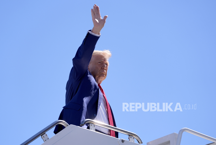 Donald Trump melambaikan tangan saat ia menaiki pesawat di Bandara Internasional Harry Reid setelah perjalanan kampanye, Sabtu, 14 September 2024, di Las Vegas.