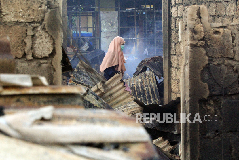 Seorang warga mengamati sisa bangunan yang rusak akibat kebakaran di Permukiman Dok IX Distrik Jayapura Utara, Kota Jayapura, Papua, Selasa (20/10/2020). Petugas kepolisian masih menyelidiki penyebab kebakaran yang menghanguskan ratusan rumah di kawasan itu. 