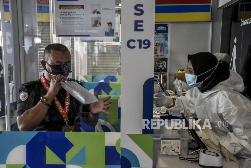 Pegawai mengembuskan napas ke dalam kantong udara untuk dites Covid-19 dengan alat GeNose C19 di Bandara Husein Sastranegara, Kota Bandung, Senin (22/3). Pemerintah memastikan perjalanan melalui jalur udara selama masa larangan mudik pada 6-17 Mei 2021 tidak diperbolehkan.