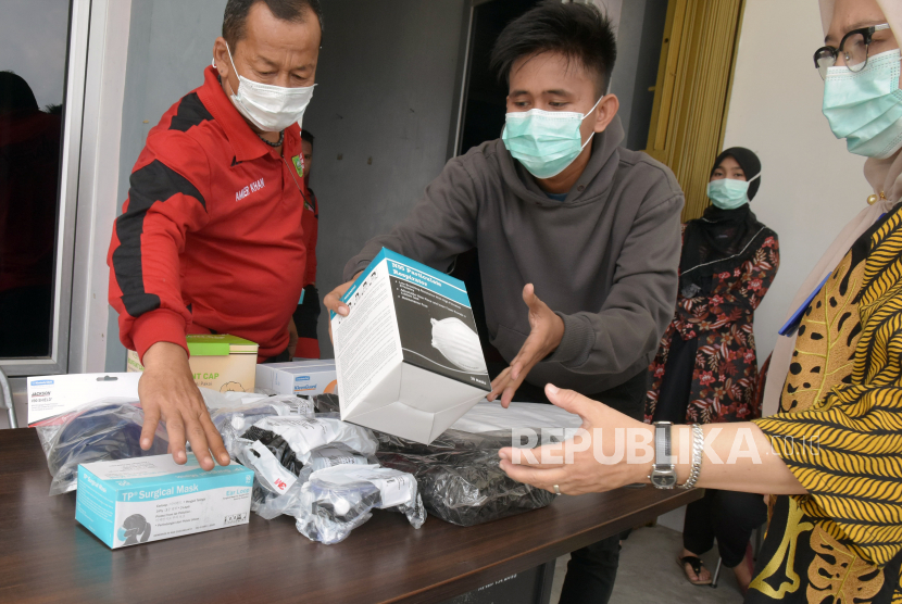 Sejumlah petugas dinas kesehatan merapikan alat pelindung diri (APD) bantuan Kementerian Kesehatan di Kota Pekanbaru, Riau, Sabtu (28/3/2020). Sebanyak 2