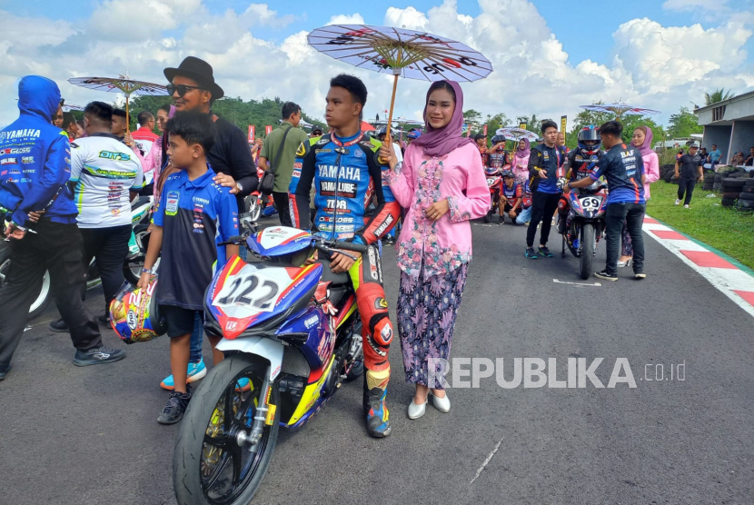 Umbrella girl mendampingi pembalap pada ajang balap motor Oneprix Indonesia Motoprix Championship 2023 Putaran 3 di Sirkuit Bukit Peusar, Kota Tasikmalaya, Jawa Barat, Ahad (9/7/2023).
