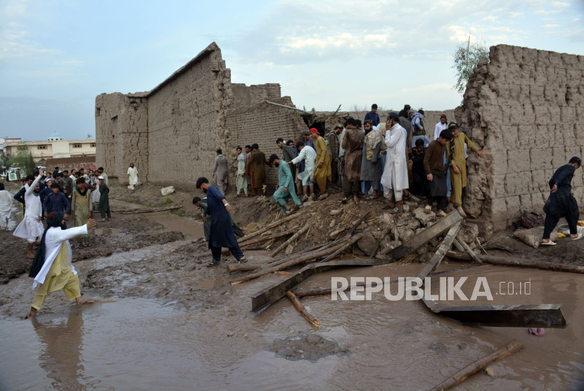  Orang-orang membersihkan puing-puing rumah yang rusak akibat tanah longsor dan hujan deras di distrik Surkhroad Jalalabad, Nangarhar, Afghanistan, Senin (15/7/2024).