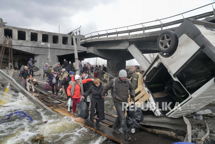 Orang-orang melintasi jalan darurat di bawah jembatan yang hancur saat melarikan diri dari kota Irpin dekat Kyiv, Ukraina (Ilustrasi). Indonesia berpeluang turut aktif selesaikan perang antara Rusia dan Ukraina  