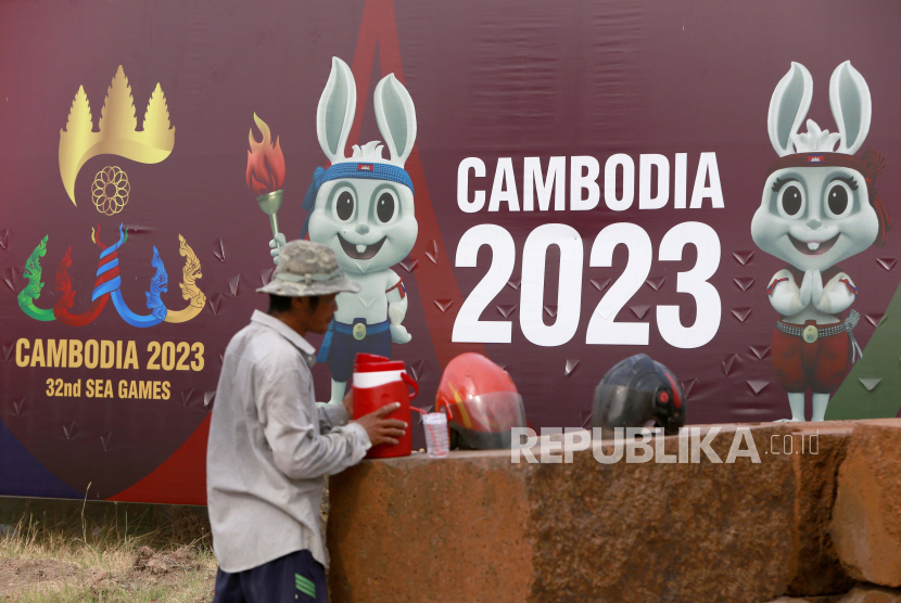 Seorang pekerja Kamboja bersantai di depan spanduk yang mengiklankan Pesta Olahraga Asia Tenggara ke-32 (SEA Games 32) di Phnom Penh, Kamboja. Di cabang bola voli putra, timnas Indonesia pada Senin (8/5/2023), akan berlaga di babak final melawan tuan rumah. (ilustrasi)