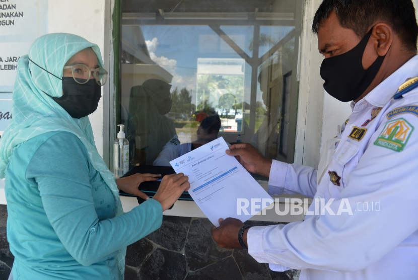 Petugas memeriksa surat sertifikat vaksin Covid-19 calon penumpang kapal saat pembelian tiket di pelabuhan Ulee Lheue, Banda Aceh, Aceh, Senin (4/10). Pemerintah menetapkan syarat perjalanan baru untuk dari dan ke luar Jawa dan Bali. 