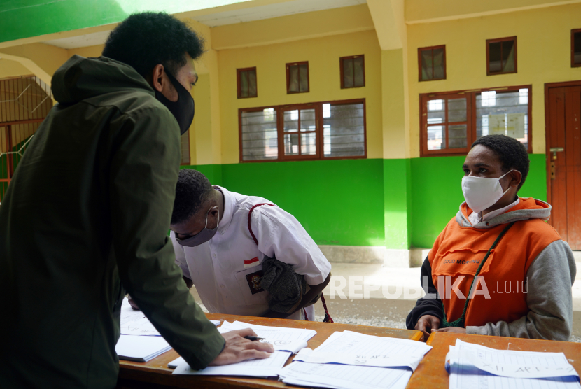 Dua siswa mengambil bahan pelajaran untuk dipelajari di salah satu SMK di Wamena, Papua, Kamis (26/11/2020). Keterbatasan sarana komunikasi dan jaringan membuat siswa disejumlah sekolah di Papua terpaksa mengambil langsung bahan mata pelajaran dengan tetap melaksanakan protokol kesehatan.