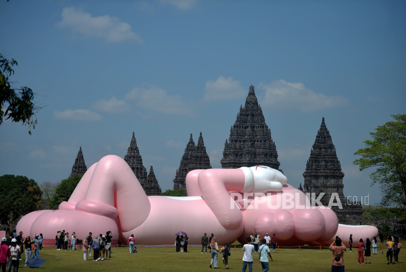 Pengunjung melihat Boneka raksasa KAWS karya seniman Brian Donelly yang menjadi ikon seni rupa kontemporer menghiasi pelataran Candi Brahma, Komplek Candi Prambanan, Yogyakarta, Rabu (23/8/2023). 