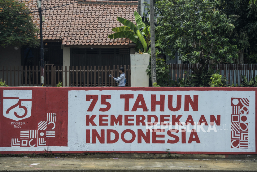 Warga melintas di dekat mural di kawasan Kampung Melayu, Jakarta, Kamis (6/8). Jumlah harian kasus baru Covid-19 di DKI Jakarta mengalami lonjakan dalam sepekan terakhir. (ilustrasi)