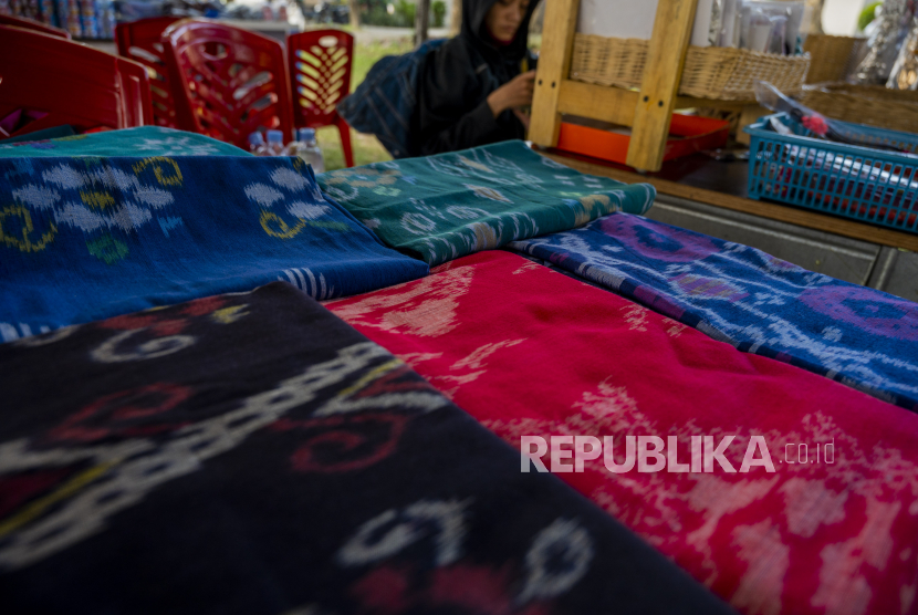 Pelaku UMKM menunggui pengunjung di dekat aneka kain batik motif khas Bomba dalam sebuah pameran di Palu, Sulawesi Tengah, Kamis (28/10).