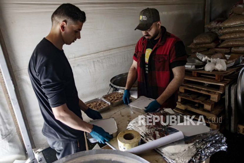 Relawan World Central Kitchen menyiapkan makanan untuk pengungsi Palestina di Rafah, selatan Jalur Gaza, 18 Maret 2024. Israel menyerang tiga kendaraan WCK dan menewaskan tujuh pekerjanya.