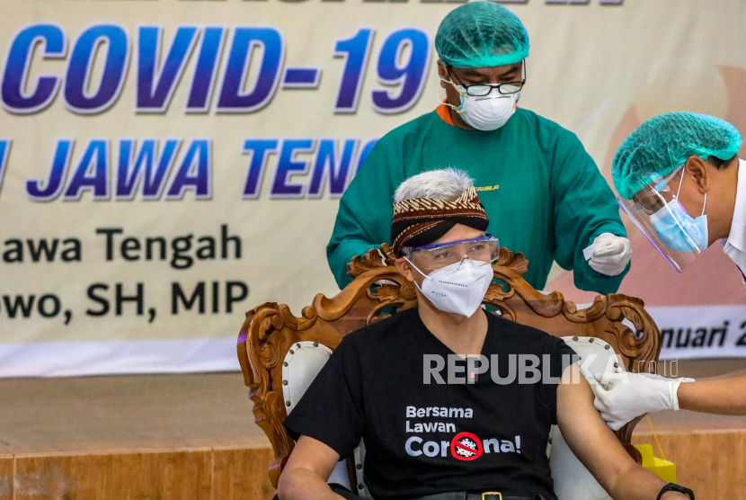 Gubernur Jawa Tengah Ganjar Pranowo (kiri) disuntik vaksin COVID-19 produksi Sinovac (CoronaVac) oleh vaksinator dokter senior spesialis penyakit dalam Zulfachmi Wahab (kanan) di RSUD Tugurejo, Semarang, Jawa Tengah, Kamis (14/1/2021). Ganjar Pranowo mendapatkan suntikan pertama di Jawa Tengah untuk menandai dimulainya program vaksinasi massal di sejumlah daerah di Jawa Tengah. 