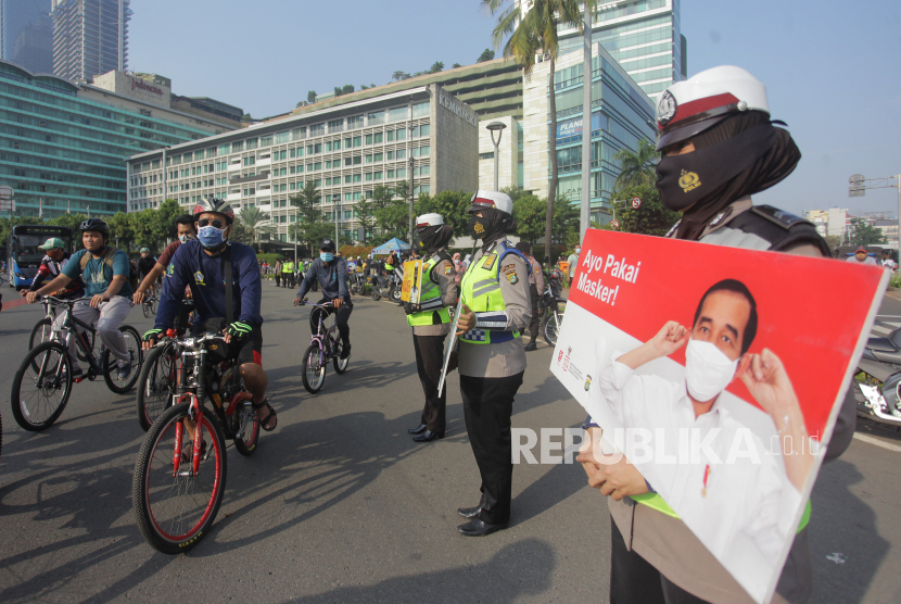 Polisi melakukan kampanye sosialisasi menggunakan masker dan cuci tangan saat hari bebas kendaraan bermotor di kawasan Sudirman, Jakarta, Minggu (8/11/2020). Polisi mengajak warga masyarakat untuk ikut berperan aktif dalam memutus mata rantai penyebaran COVID-19 dengan menggunakan masker dan rajin mencuci tangan. 