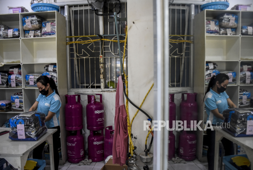 Pekerja merapikan pakaian di salah satu tempat usaha laundry di Jalan Dipati Ukur, Kota Bandung, Senin (26/7). Pemerintah memperpanjang Pemberlakuan Pembatasan Kegiatan Masyarakat (PPKM) Level 4 di sejumlah wilayah Pulau Jawa dan Bali hingga 2 Agustus dengan berbagai penyesuaian aturan, diantaranya memperbolehkan PKL, toko kelontong, laundry, pangkas rambut, rumah makan, pedagang asongan dan bengkel kecil untuk beroperasi hingga pukul 20.00 dengan protokol kesehatan ketat. Foto: Republika/Abdan Syakura