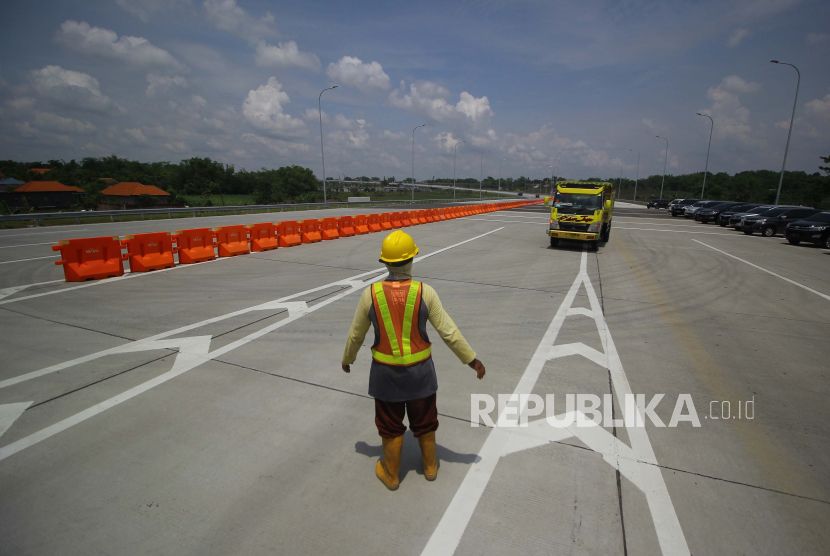 Pekerja beraktivitas di jalan tol Krian-Legundi-Bunder-Manyar (KLBM) seksi 1 di Gresik, Jawa Timur, Selasa (24/11). Presiden Joko Widodo (Jokowi) memastikan tahun 2021 ini akan diwarnai beragam proyek pembangunan infrastruktur.