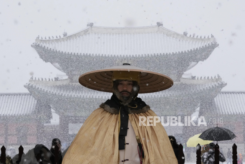 Penjaga kerajaan berdiri di luar Istana Gyeongbok, Seoul, Korea Selatan di tengah guyuran salju Kamis, (15/12/2022).. Salah satu istana pada masa Dinasti Joseon dan landmark di Seoul, Korea Selatan. 