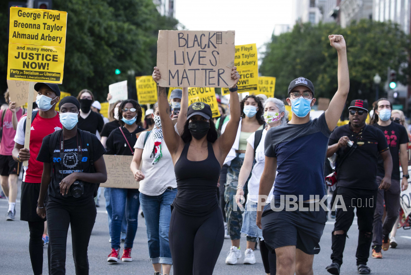  Para pengunjuk rasa berbaris sebelum menutup Interstate 395, sebuah jalan raya yang melintasi ibukota negara itu, selama protes untuk menuntut keadilan bagi George Floyd dan kesetaraan rasial, di Washington, DC, AS, 15 Juni 2020. Para pengunjuk rasa berlutut di tanah dan lalu lintas paksa untuk berhenti
