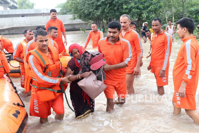 Personel Pasukan Tanggap Bencana Nasional (NDRF) menyelamatkan penduduk dari daerah banjir di dataran rendah sungai Yamuna di New Delhi, India, (13/7/2023).