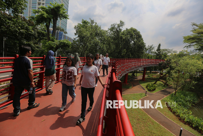 Pengunjung berwisata di ruang terbuka hijau (RTH) Taman Bendera Pusaka, Kebayoran Baru, Jakarta Selatan, Senin (23/3/2026). Taman Bendera Pusaka menjadi destinasi wisata baru ramah anak dan gratis yang dapat dimanfaatkan untuk berwisata pada hari libur lebaran idul fitri di Jakarta. Taman yang baru diresmikan oleh Gubernur DKI Jakarta, Pramono Anung tersebut menyediakan sejumlah fasilitas seperti area jogging track, playground anak, kolam, lapangan basket, jembatan hingga lapangan padel.