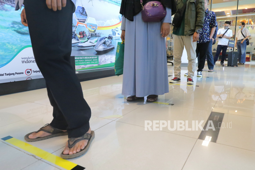 Penumpang mengantre di lantai yang telah diberi stiker panduan jarak di Bandara Depati Amir, Kota Pangkalpinang, Kepulauan Bangka Belitung, Kamis (19/3/2020) (ilustrasi).