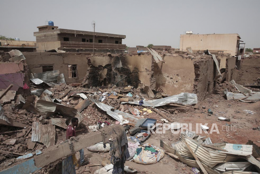  Seorang pria berjalan melewati sebuah rumah yang terkena serangan dalam pertempuran baru-baru ini di Khartoum, Sudan, Selasa (25/4/2023). Para jenderal yang bertikai di Sudan telah berjanji untuk mengamati gencatan senjata tiga hari baru yang ditengahi oleh Amerika Serikat dan Arab Saudi untuk mencoba menarik pasukan Afrika. 