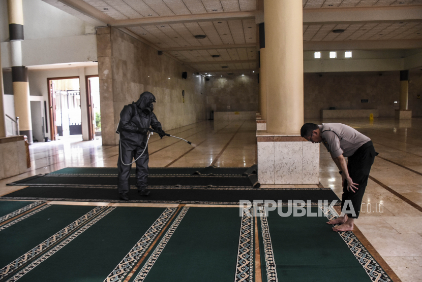 Personel dari Unit Kimia Biologi Radioaktif (KBR) Gegana Brimob Polda Jabar menyemprotkan cairan disinfektan di sajadah Masjid Raya Bandung, Jalan Dalem Kaum, Kota Bandung, Sabtu (14/3).   