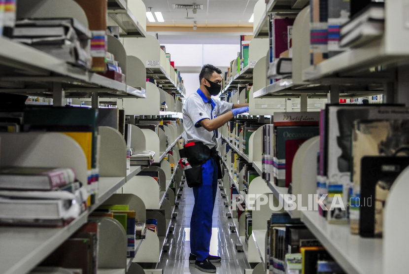 Petugas membersihkan rak buku di Perpustakaan Nasional, Jakarta, Rabu (10/6). Perpustakaan Nasional menerapkan sejumlah protokol kesehatan menjelang pembukaan kembali pada Kamis (11/6) dan membatasi pengunjung sebanyak 1