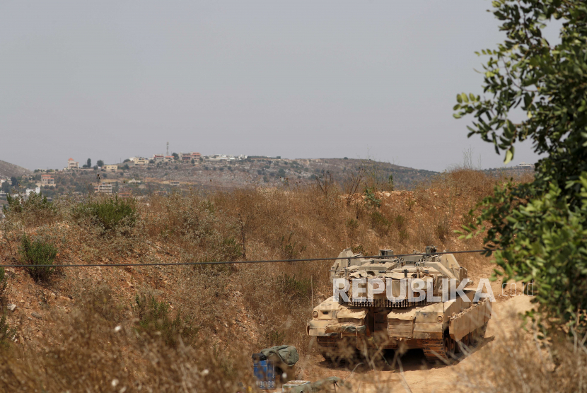 Sebuah tank Israel mengambil posisi di perbatasan Israel-Libanon di sebelah desa Libanon Dier Mimas di latar belakang, 28 Juli 2020. Israel pada 27 Juli mengatakan pasukan Israel menggagalkan upaya infiltrasi Hezbollah dari Libanon. Namun Hizbullah membantah terlibat dalam bentrokan lintas batas. 