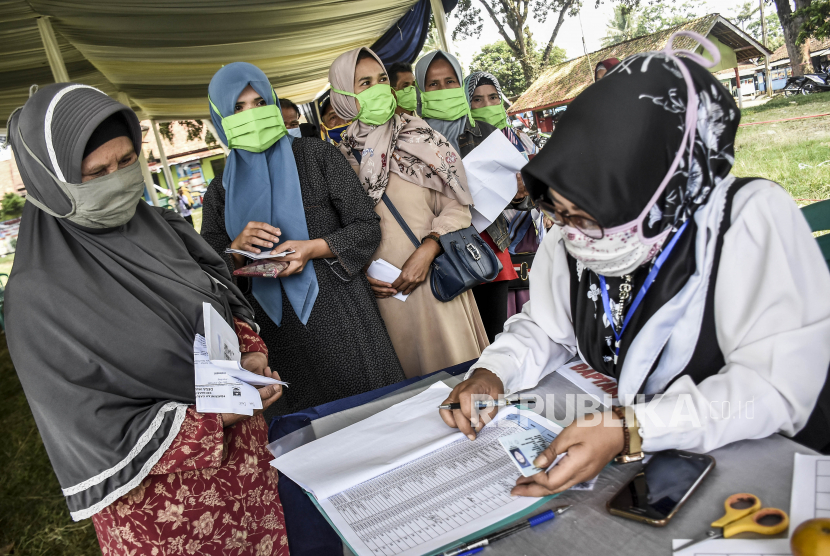 Sejumlah warga mengantre untuk mendapatkan Bantuan Langsung Tunai Dana Desa di Lapangan Desa Margalaksana, Cipendeuy, Kabupaten Bandung Barat, Jumat (29/5).