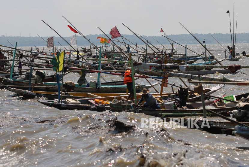 Sejumlah nelayan menjaga perahunya saat terjadinya gelombang tinggi dan angin kencang di pesisir Bulak, Surabaya, Jawa Timur, Kamis (27/5/2021). Angin kencang dan gelombang tinggi yang diprediksi berlangsung sampai tiga hari tersebut tidak hanya mengakibatkan nelayan tidak bisa melaut, juga menyebabkan satu perahu nelayan terbalik. 