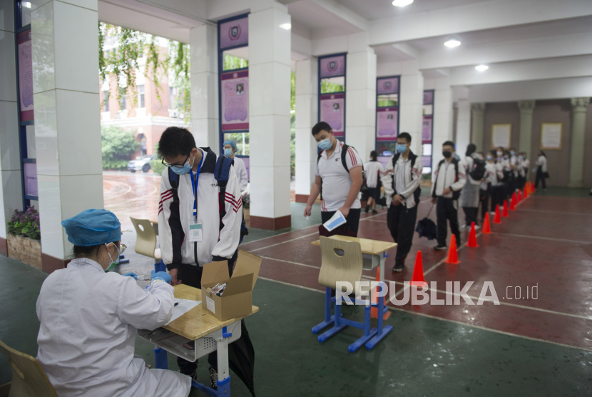 Siswa kelas sembilan mengikuti tes wajib virus corona di sebuah sekolah di Wuhan, Provinsi Hubei, Cina, Kamis (14/5). Imbas adanya pasien virus crona baru, pemerintah berencana untuk menguji semua warga negara