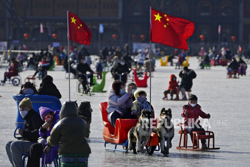 Warga menikmati hari yang cerah di Danau Houhai yang membeku di Beijing.