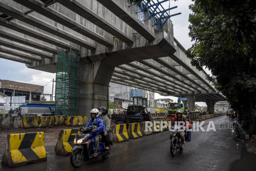 Kendaraan melintas di samping area pembangunan lintas atas (flyover) Kopo di Jalan Soekarno Hatta, Kota Bandung, Jawa Barat, Jumat (17/12). 