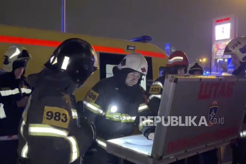 Petugas penyelamatan Rusia di dekat tempat konser Balai Kota Crocus yang terbakar menyusul penembakan di Krasnogorsk, di luar Moskow, Rusia,  (22/3/2024).