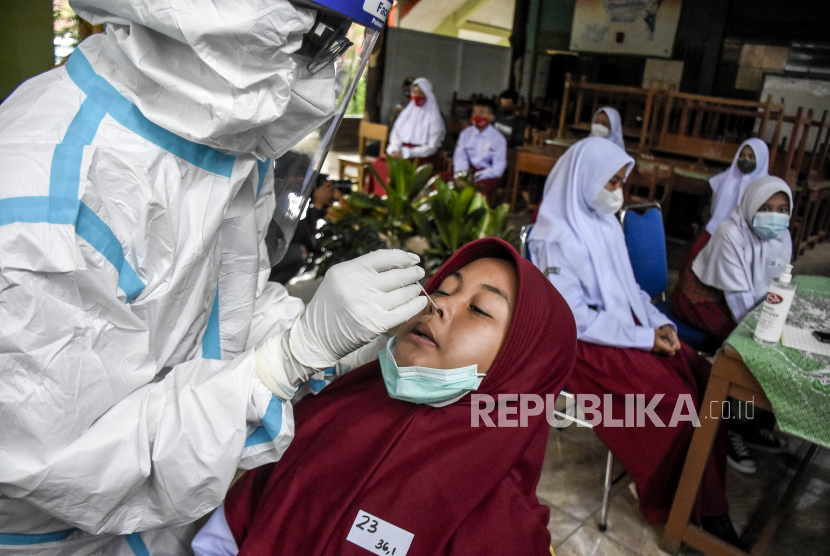 Petugas kesehatan melakukan tes usap antigen ke pelajar Kota Bandung