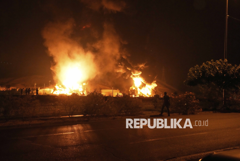 Kobaran api terlihat di fasilitas penyimpanan minyak Iran yang terbakar akibat serangan Israel di Teheran, Iran, Ahad (15/6/2025).