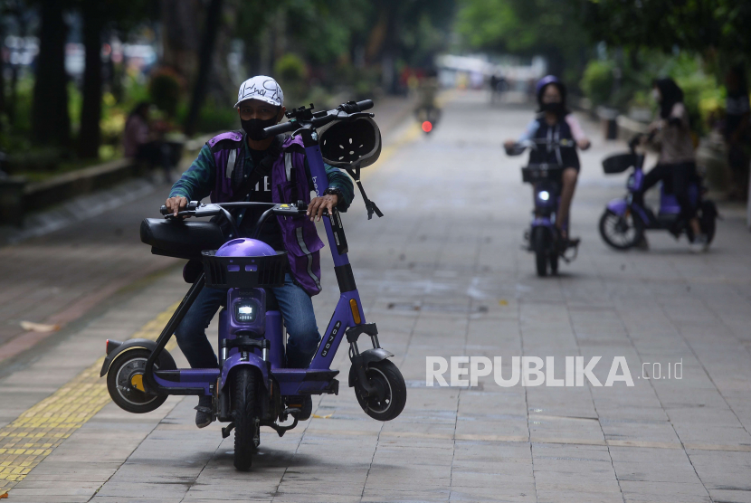 Petugas mengangkut sepeda listrik milik PT Beam di jalur pedestrian Kebun Raya Bogor, Jawa Barat, Sabtu (24/12/2022). 