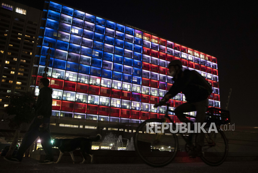  Seorang pria Israel mengambil gambar gedung kotamadya Tel Aviv yang diterangi dengan bendera Amerika Serikat di Tel Aviv, Israel, Kamis, 7 Januari 2021. Para pejabat mengatakan, pajangan itu adalah tanda solidaritas dengan Amerika Serikat. Serikat dan dukungan untuk demokrasi.