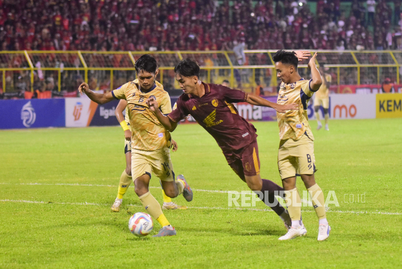 Pesepak bola PSM Makassar Andi Harjito (tengah) menggiring bola melewati pesepak bola Arema FC Jayus Hariono (kiri) dan Arkhan Fikri (kanan) pada laga lanjutan BRI Liga 1 2023/2024 di Stadion Gelora BJ Habibie, Parepare, Sulawesi Selatan, Jumat (20/10/2023). PSM Makassar menang atas tim tamu Arema FC dengan skor 3-0. 