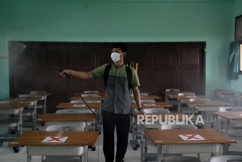 Petugas menyemprotkan disinfektan di SMPN 252 Jakarta pada Jumat (14/1), yang sedang mengehentikan sementara kegiatan pembelajaran tatap muka (PTM) setelah terdapat satu siswa yang positif Covid-19.