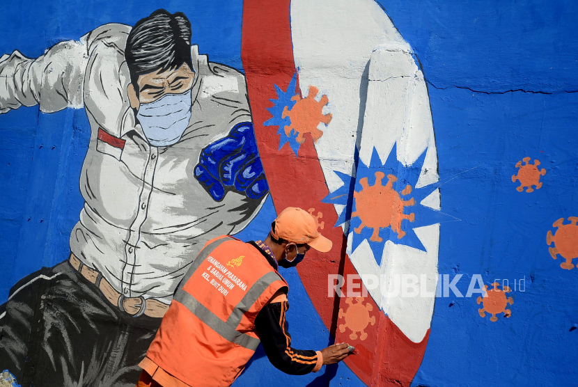 Angka Kesembuhan Pasien Covid-19 di Bangka Meningkat. Petugas PPSU Bukit Duri menyelesaikan pembuatan mural yang berisi pesan waspada penyebaran virus corona.